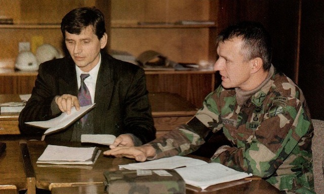 A local Bosnian official (Mr. Sefket) and the 96th CA Bn.'s Armstrong go over a list of potential basing locations for incoming American units.