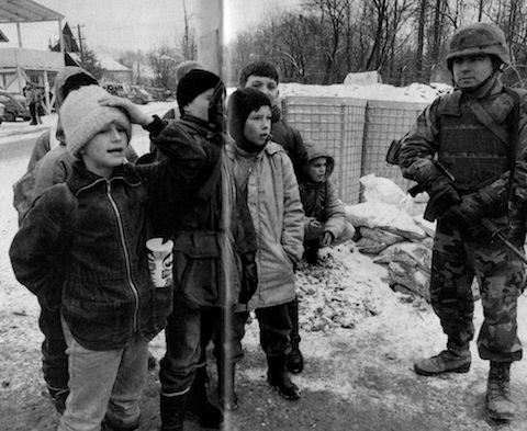 Sgt. Jason Hall keeps an eye on local kids fascinated by the American presence.