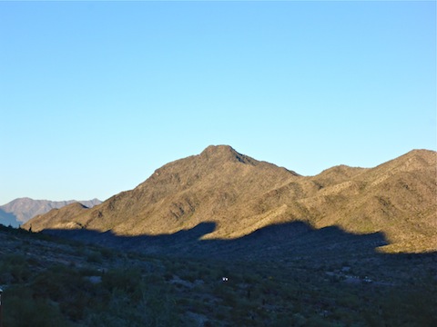 Sun just starting to shine on Maricopa Peak in the Ma Ha Tuak Range. Note the car still using its headlights on Summit Rd.