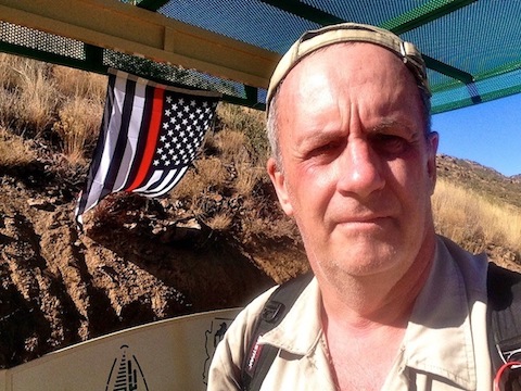 Me in front of a firefighter memorial flag hanging at the Yarnell Hill overlook.