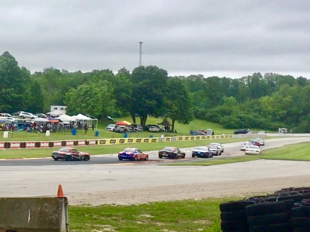 SCCA SM class Spec Miata's charge through Turn 6 into the Hurry Downs. One car got a little wide.