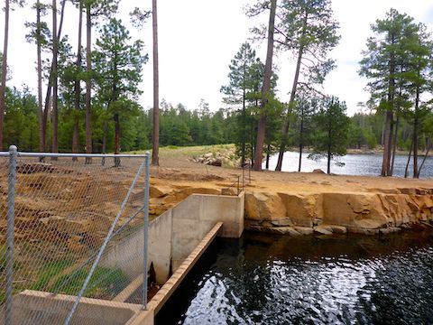 Looking across the fenced spillway, towards Willow Springs Lake earthen dam.