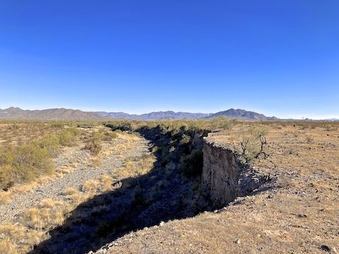 Cave Creek and Cliff Walk Trail's eponymous "cliff". Really a 30 ft. caliche bluff. You really need a mid-afternoon, or later, sun for decent lighting. In the distance, the black mountain is ... uh ... Black Mountain.