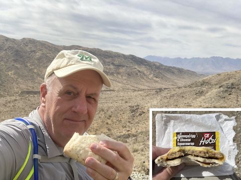 Enjoying some hiking food, while taking a break at the stone chair halfway down Alta Trail. Looking southwest to the Loop 202 and Sierra Estrella.