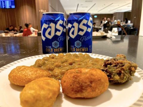 Korean beer, chickpea curry, and pakora at Singapore Airlines' SilverKris Business Lounge at Changi Airport.