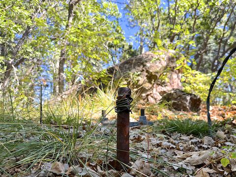 The big boulder is the summit of Mahan Mountain. The water-damaged summit log is tucked in a crevice on the back side. In the foreground is one of three lookout tower supports I found. There is also a cistern, and a bit of foundation.