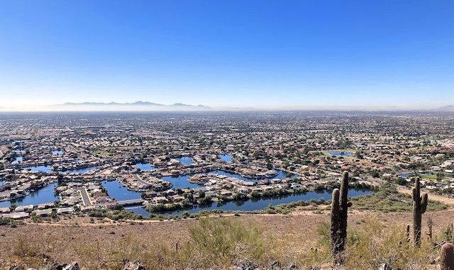 Arrowhead Lakes, as viewed from the summit of Arrowhead Point. Sierra Estrella peaking through the I-10 smog, 25 miles away. Coachwhip Trail traverses the area below the lakes.